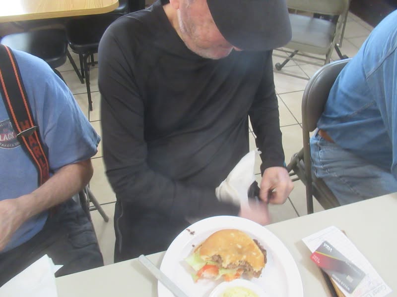 Steve is trying to coyly extricate his napkin from his zipper.