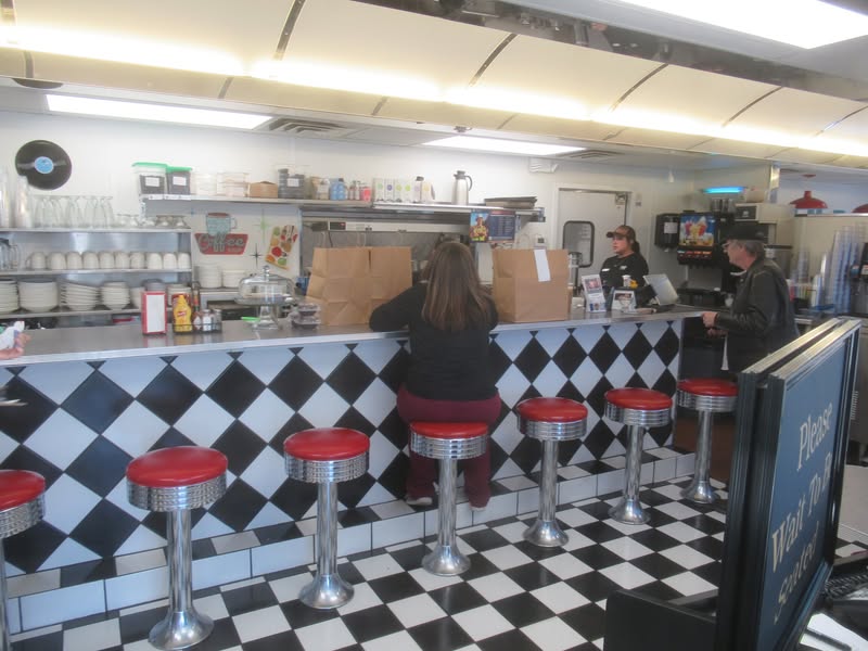John is paying his bill at the Diner.